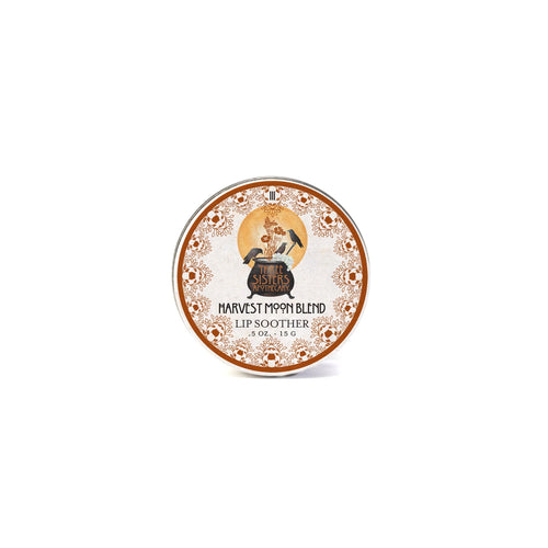 A round tin of Three Sisters Apothecary Harvest Moon Lip Soother, featuring a vintage illustration of a woman and orange floral borders, labeled with the brand Three Sisters Apothecary.