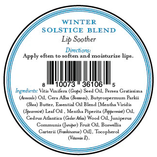 A round label for Three Sisters Apothecary Winter Solstice Lip Soother shows directions to apply often and a natural ingredients list with essential oils, all in blue and black text on white around a barcode.