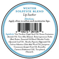 A round label for Three Sisters Apothecary Winter Solstice Lip Soother shows directions to apply often and a natural ingredients list with essential oils, all in blue and black text on white around a barcode.