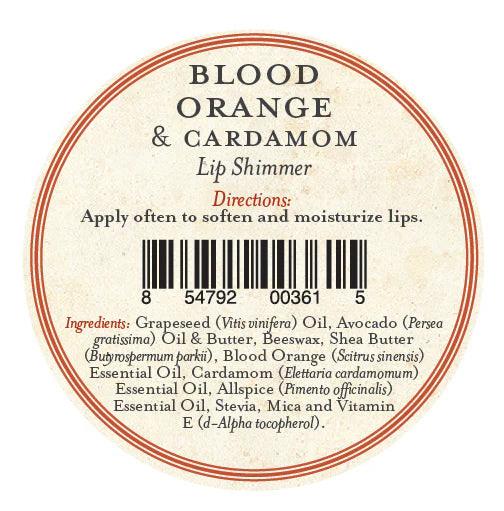Round label for Three Sisters Apothecary Blood Orange & Cardamon Lip Shimmer hydrating balm, directions to apply often, barcode, and ingredients: natural beeswax, oils, butters, essential oils. Red/black text on cream background.