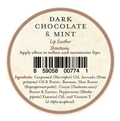 A round lip balm label for Three Sisters Apothecary Dark Chocolate & Mint Lip Soother shows directions, a barcode at the center, and natural ingredients such as oils, beeswax, shea butter, cocoa, peppermint, and vitamin E to moisturize lips.