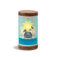 A 20oz cylindrical container of Three Sisters Apothecary Therapeutic Foaming Winter Solstice, featuring a blue and yellow label with birds around a cauldron and a sunburst in the background.