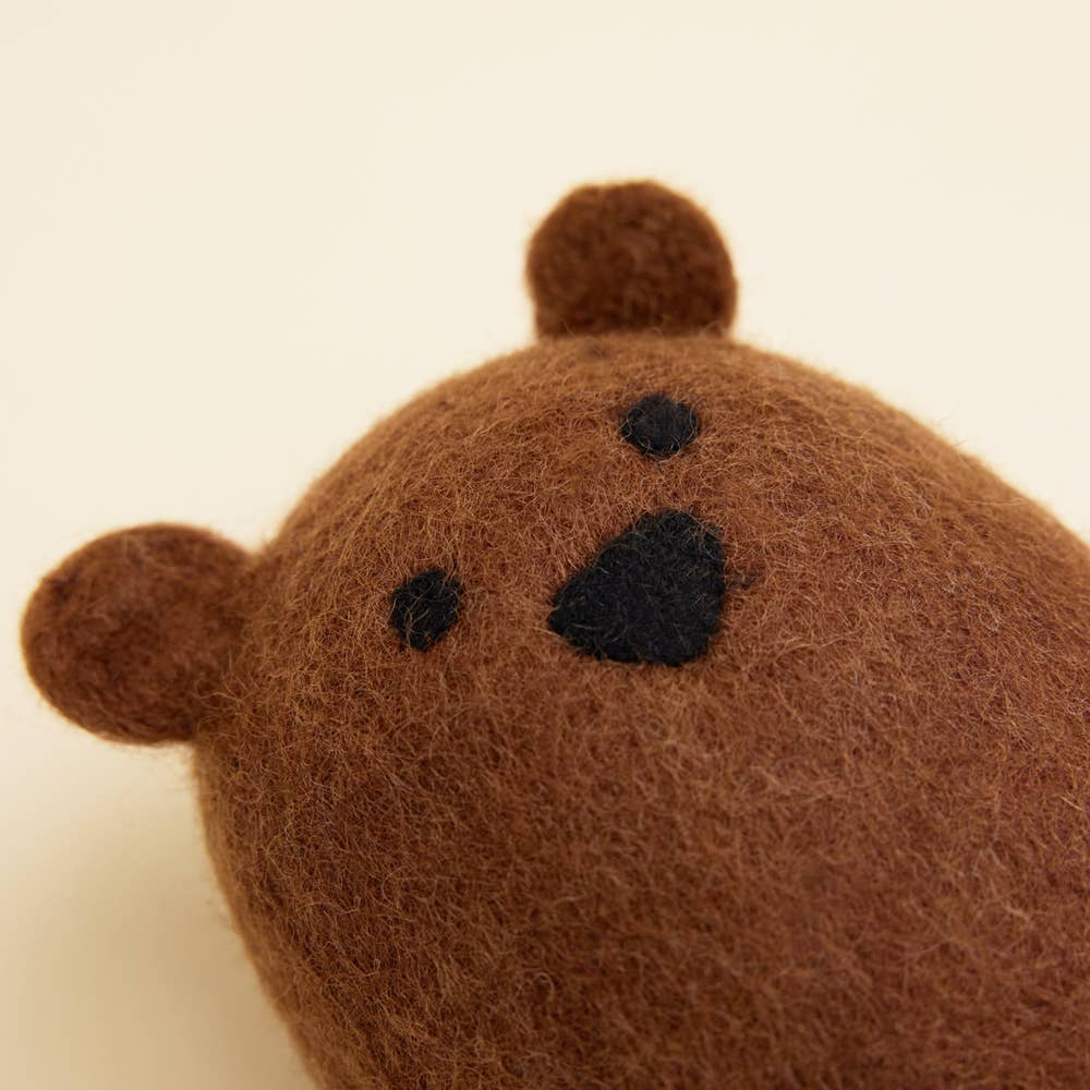 A close-up of the MODERNBEAST Wool Brown Bear Dog Toy, featuring soft brown wool, small round ears, and simple black-stitched nose and eyes, displayed against a plain light background.