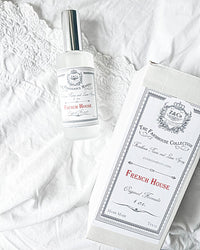 A clear spray bottle labeled "Z&Co. Salt Farmhouse Room/Linen Spray" by Z&Co. rests on white lace beside its matching box, both featuring the Z&Co. brand—an elegant, handcrafted Texas room spray that adds a charming farmhouse touch.
