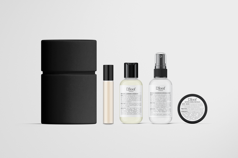 L'floof Travel-Size Grooming Set by L'floof features five minimalist, eco-friendly products in black and white: a cylindrical container, roll-on bottle, two pump or spray bottles, and a round jar—all with labeled text on a white background.