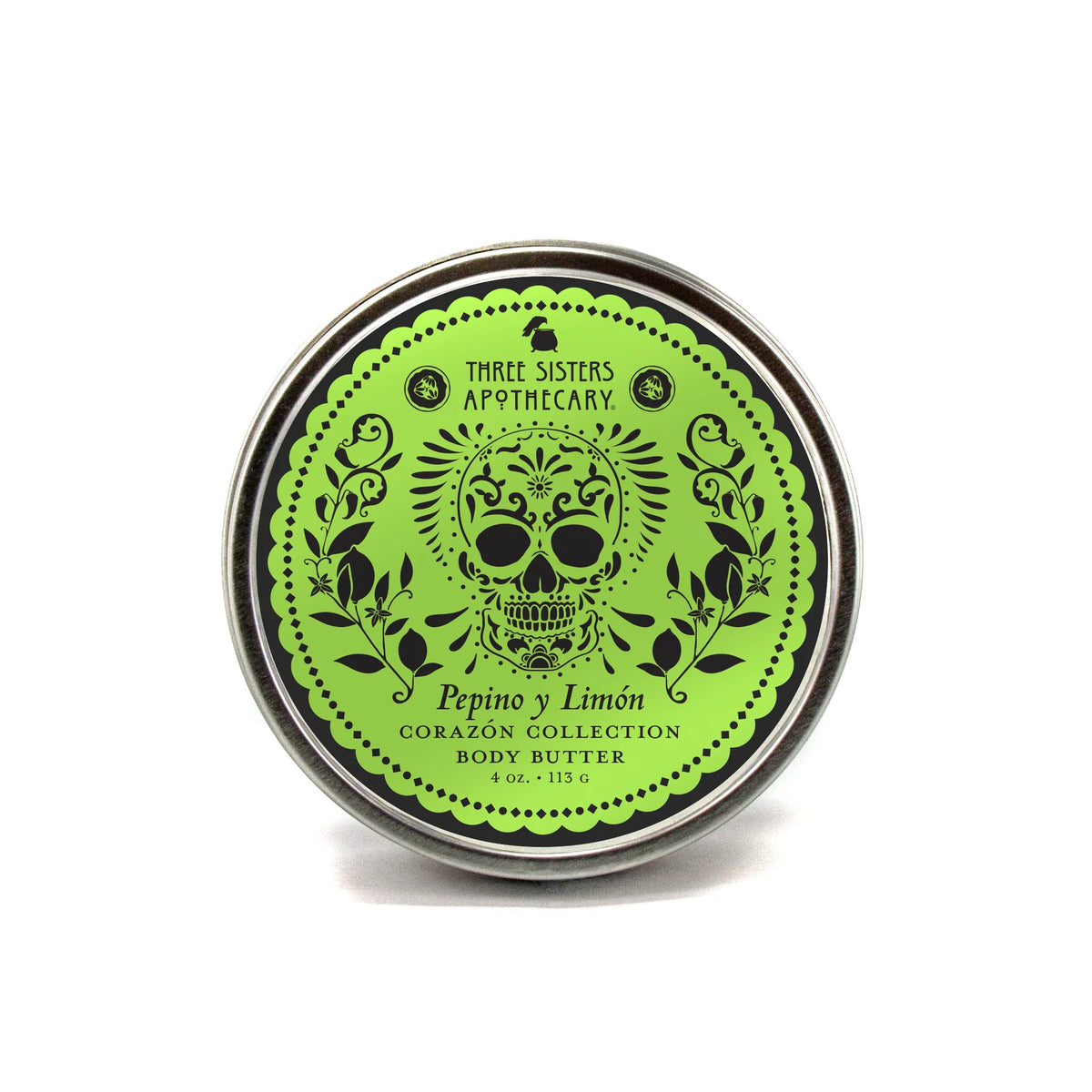 A round tin of Three Sisters Apothecary Pepino y Limón Body Butter from the Corazón Collection, featuring a green label with a sugar skull, floral designs, and providing natural hydration.