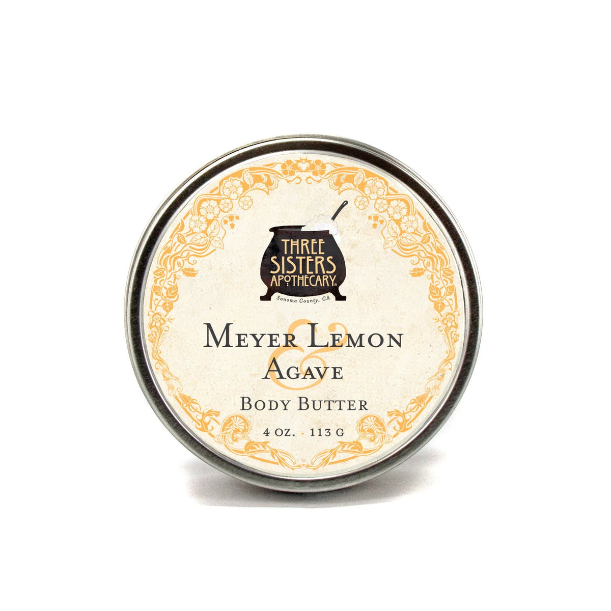 A round tin of Three Sisters Apothecary Meyer Lemon & Agave Body Butter, 4 oz (113 g), features a decorative yellow floral border and offers a fresh scent with rich, natural hydration.