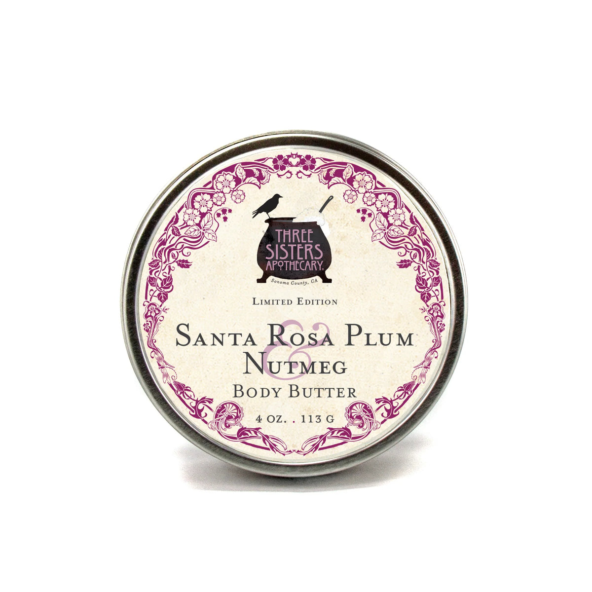 A 4 oz. round tin of Three Sisters Apothecary Santa Rosa Plum & Nutmeg Body Butter features a vintage-style label with a purple border and is enriched with shea butter for rich, natural moisture.