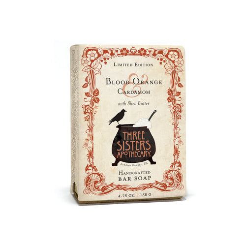 Three Sisters Apothecary Blood Orange & Cardamom Bar Soap is a 4.75 oz handcrafted soap with shea butter, featuring ornate floral borders and a black cauldron logo on the package.