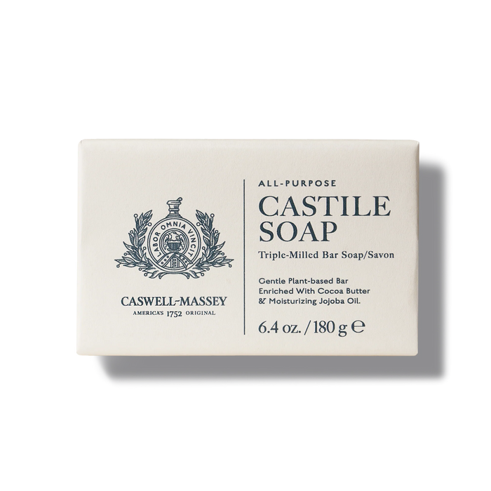 Front view of a Caswell-Massey Castile Soap Bar box. The classic design with a crest logo highlights its benefits as a plant-based, all-purpose soap ideal for sensitive skin. Triple-milled and enriched with cocoa butter and jojoba oil, it weighs 6.4 oz (180g).