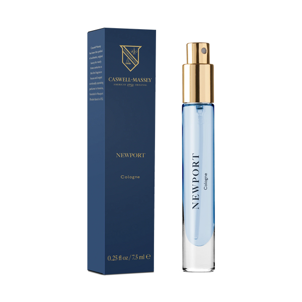 A blue and gold Caswell-Massey Newport Cologne 7.5ml spray bottle stands beside its matching box featuring the brand logo, gold text, and bottle size.