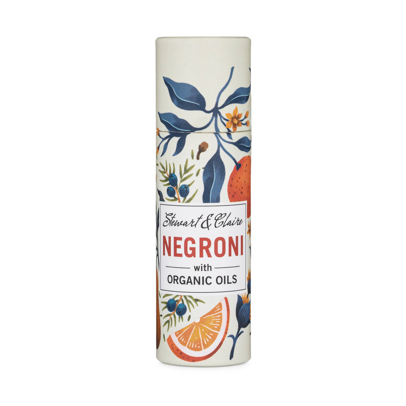 Stewart & Claire Negroni Lip Balm in a paper tube, made with organic oils and adorned with a vibrant botanical and citrus design on white—ideal for eco-friendly lip care.
