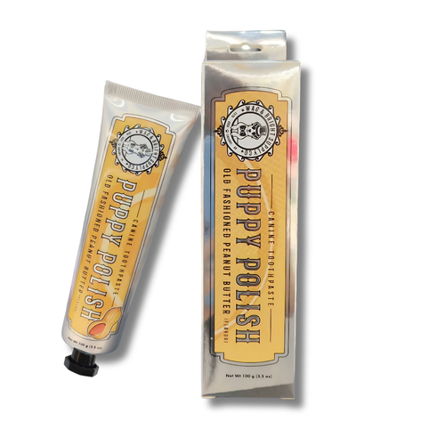 A tube and box of Wag & Bright Supply Co. Puppy Polish Toothpaste - Old Fashioned Peanut Butter, in vintage-style yellow and white packaging with black text, a peanut illustration, and natural ingredients highlighted.