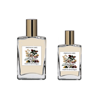 Two clear glass bottles with gold caps, labeled "FRENCH GIRL Figue Boisée Organic Vegan Woody Aromatherapy Perfume," contain light-colored, oil-based fragrance crafted with natural essential oils by FRENCH GIRL.