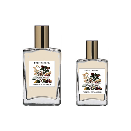 Two clear glass bottles with gold caps, labeled "FRENCH GIRL Figue Boisée Organic Vegan Woody Aromatherapy Perfume," contain light-colored, oil-based fragrance crafted with natural essential oils by FRENCH GIRL.