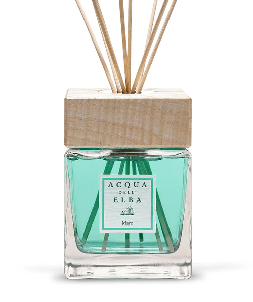 A 500ml Acqua dell'Elba Reed Diffuser Mare in a glass bottle with turquoise liquid, wooden cap, and reed sticks. The label features the brand and product name, evoking a fresh Mediterranean aquatic scent.