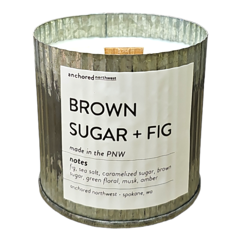 Introducing the Anchored Northwest Brown Sugar + Fig Rustic Vintage Farmhouse Wood Wick Candle, a metallic, ridged candle container from Anchored Northwest. This soy wax candle is made in the Pacific Northwest (PNW) and features delightful scent notes of fig, sea salt, caramelized sugar, brown sugar, green floral, musk, and amber.