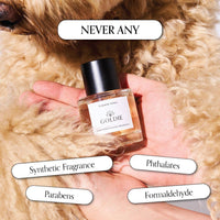 A hand holds a bottle of Goldie Dog Fragrance- Summer Tonic, a natural dog perfume, surrounded by curly light fur. Text bubbles read: "NEVER ANY" above and "Synthetic Fragrance," "Parabens," "Phthalates," and "Formaldehyde" below.