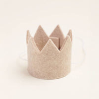The MODERNBEAST Wool Pet Party Crown is a small, light beige crown with pointed tips and an adjustable elastic band—perfect for your pet on any special occasion. Shown against a plain off-white background.