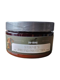 Fox + Hound Stormies Paw Protection – All Season is a 4 oz round jar with a silver lid, featuring a dog image and label text, delivering premium paw balm for effective dog paw pad care.