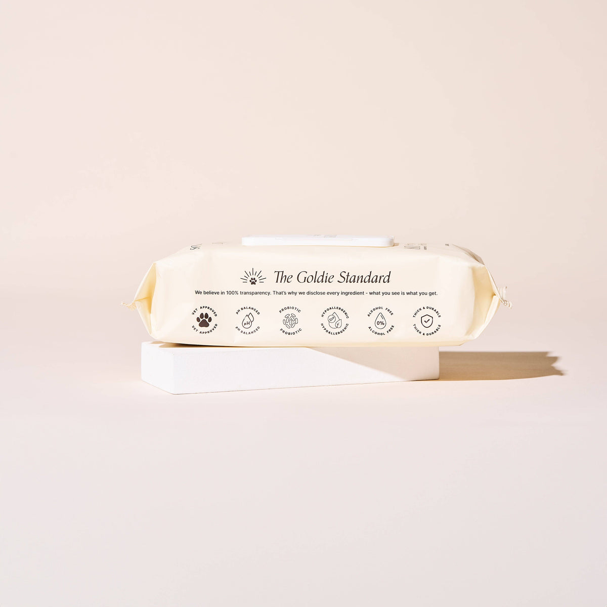 A light beige pack of Goldie - So Fresh, So Clean Probiotic Wipes by Goldie rests on a white block against a pale background, with icons and text on the packaging highlighting its hypoallergenic and probiotic features.