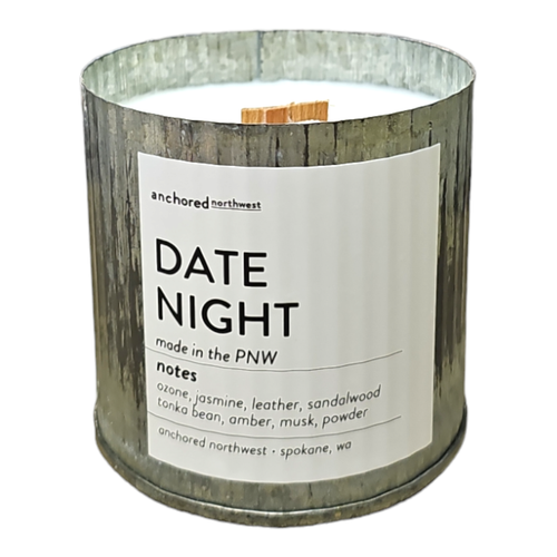 A Date Night Rustic Vintage Farmhouse Candle by Anchored Northwest in a metal container has a wooden wick with scents of ozone, jasmine, leather, sandalwood, tonka bean, amber, musk, and powder. Made in Spokane, WA.