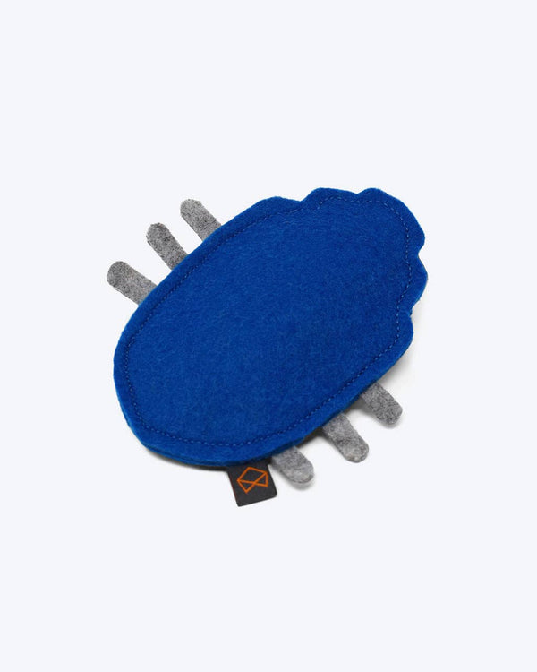 The MODERNBEAST - Beast Bugs Wool Cat Toy with Organic Catnip is a blue, irregularly oval wool toy with five short gray felt protrusions and a small black tag featuring an orange logo, shown on a white background.