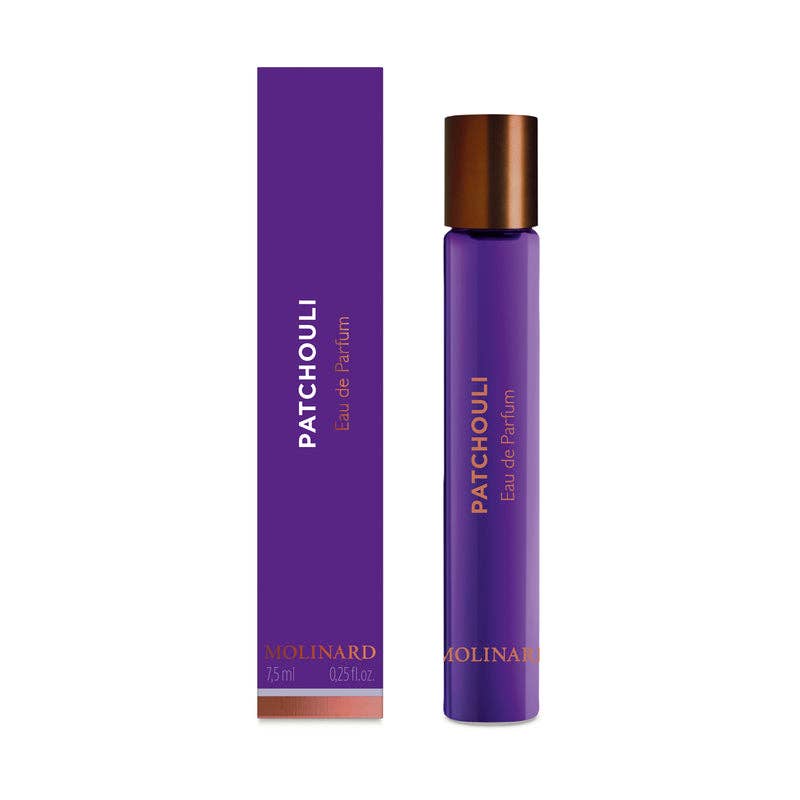 A purple Molinard Patchouly Eau de Parfum Roll-On stands beside its matching box, featuring a copper cap and containing 7.5 ml (0.25 fl oz) of rich patchouli fragrance.
