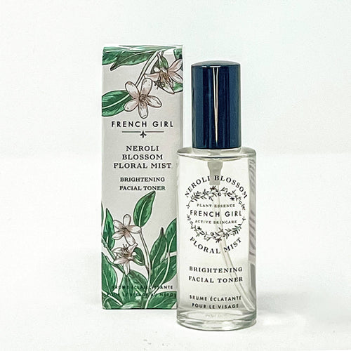 A bottle of FRENCH GIRL Organic Floral Face Mist & Toner - Neroli Blossom stands before its floral-themed box, both adorned with green leaves and white flowers—a lovely addition to your natural skincare routine.