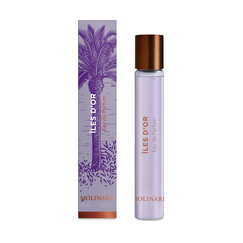 A Molinard Iles d'Or Eau de Parfum Roll-On stands beside its purple and copper box with a palm tree illustration. The slim bottle features a copper cap and lilac label, reflecting the elegant style of Molinard fragrances.