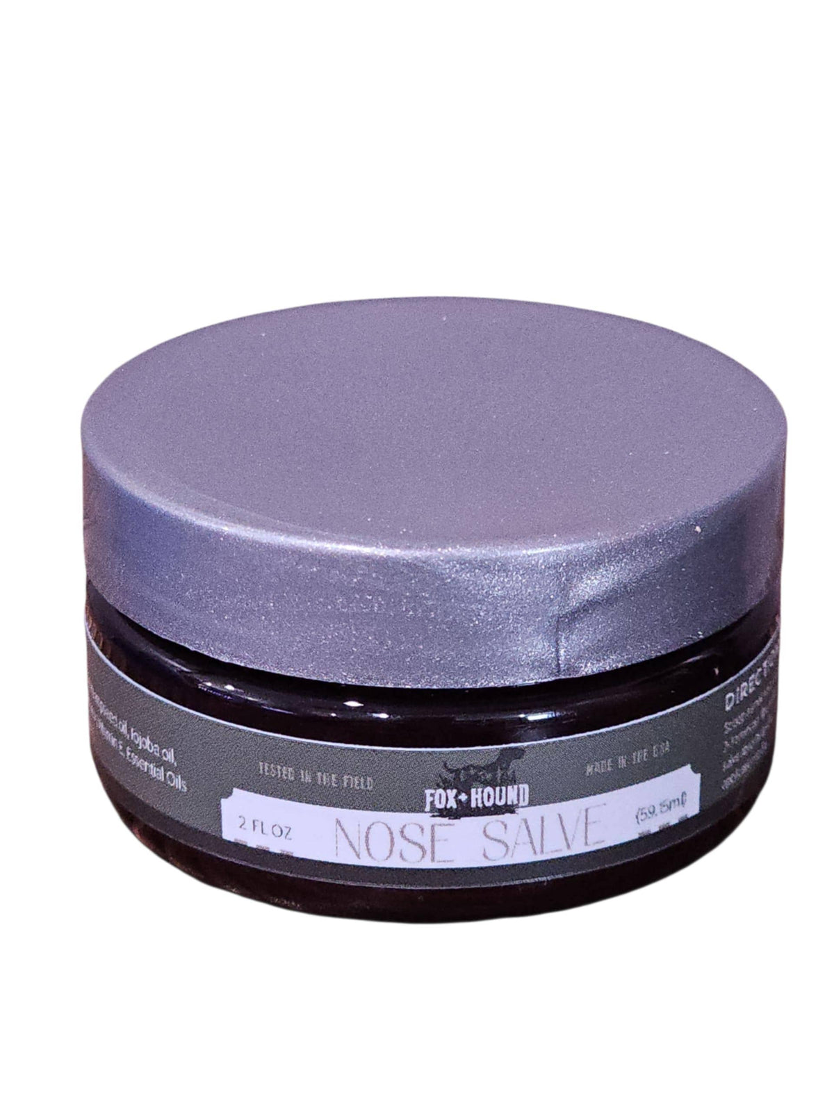 A round, dark jar with a silver lid labeled "Fox + Hound Nose Salve For Dogs, Butter, Balm." This natural balm by Fox + Hound moisturizes and soothes dry dog noses with gentle ingredients. 2 fl oz size.