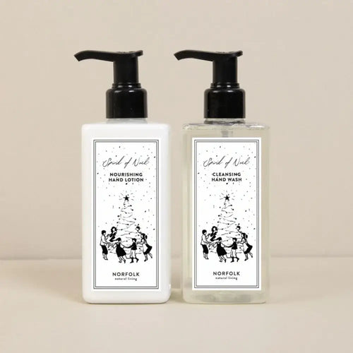 The Norfolk Natural Living Spirit of Noel Christmas Hand Care Set features nourishing hand lotion and botanical hand wash in pump bottles with festive black-and-white holiday illustrations—ideal for gifting this season.