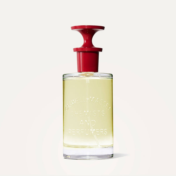 Caswell-Massey Number Six Eau de Parfum 100mL features pale yellow liquid in a glass bottle embossed with “CHEMISTS AND PERFUMERS” and topped with a red laboratory-style cap, reflecting Caswell-Massey’s fragrance heritage.