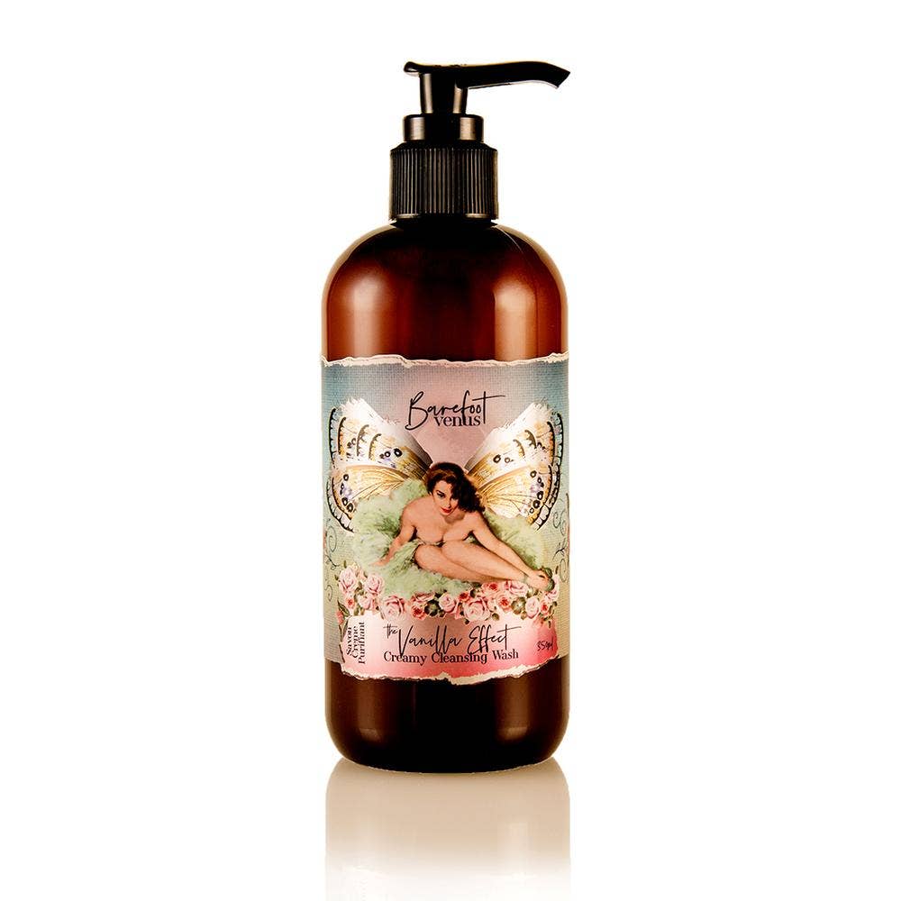 A bottle featuring a black pump, labeled with "Barefoot Venus The Vanilla Effect Cleansing Hand & Body Wash," showcases artwork of a winged woman surrounded by flowers alongside the phrase "The TRUE VANILLA Effect." This plant-derived hand and body wash is infused with nourishing extracts and provides a gentle cleanse.