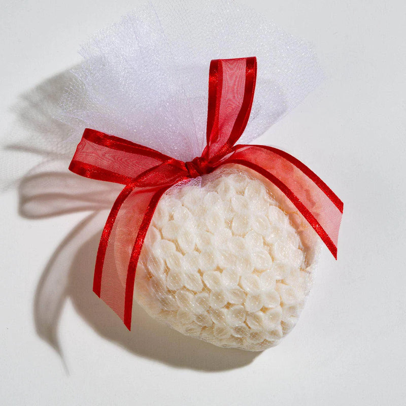 The Sonoma Lavender - Lavender Scented Goats Milk Heart Soap Elegant Ivory by Sonoma Lavender, wrapped in bubble wrap and white mesh with a red ribbon, rests on a white background. It features calming lavender essential oil and soothing goat’s milk.