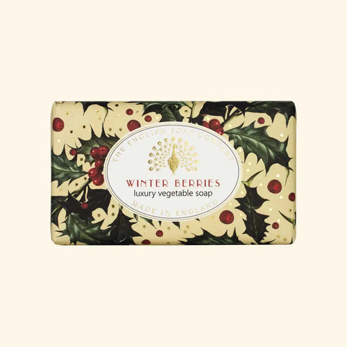 The English Soap Co. Winter Berries Festive Christmas Soap from The English Soap Company, part of their Christmas Collection, is elegantly wrapped in ornate paper adorned with holly leaves and red berries. The label reads "Winter Berries" and "Made in England." Enriched with shea butter, the packaging showcases a festive holiday theme.