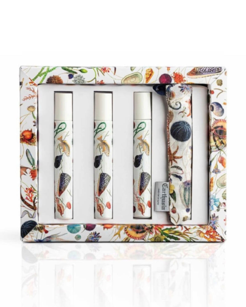 Introducing the Carthusia A'mmare Roll-on Set by Carthusia I Profumi de Capri: a vibrant gift set showcasing a nature-inspired design. This exquisite set features three white-capped roll-on tubes infused with Jojoba Oil and an additional white item, all beautifully illustrated with flora and fauna motifs, packaged inside a box adorned with matching botanical patterns.