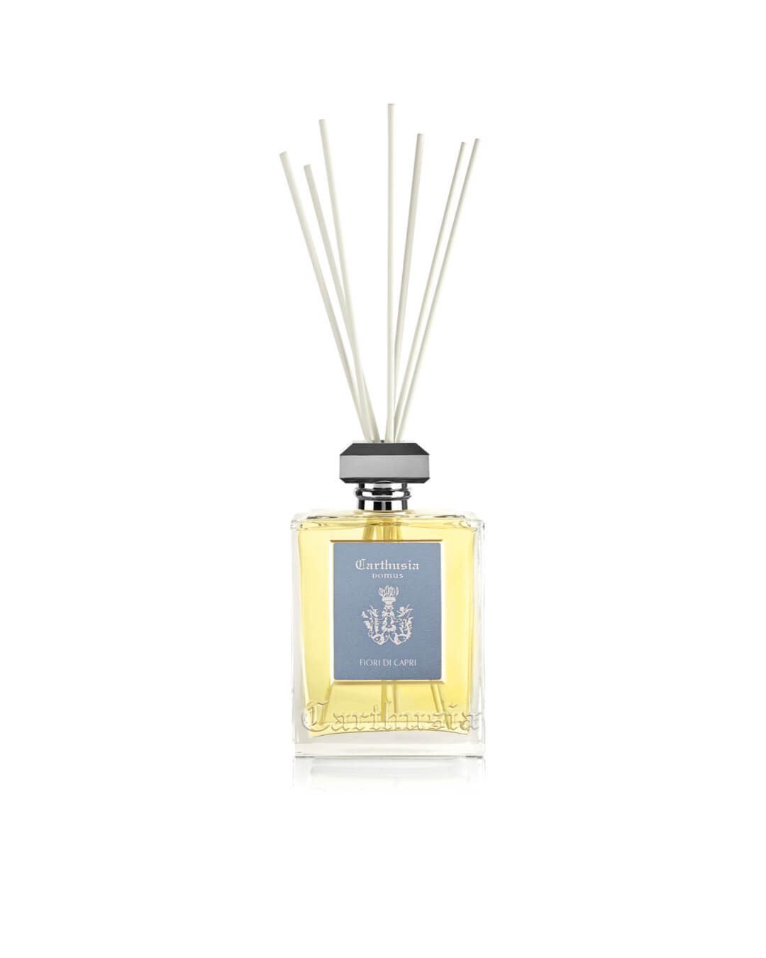 The Carthusia I Profumi de Capri Fiori di Capri Reed Diffuser (230ml) features a clear glass bottle with light yellow liquid, gray cap, white reeds, and a blue label to beautifully enhance your home's fragrance and décor.