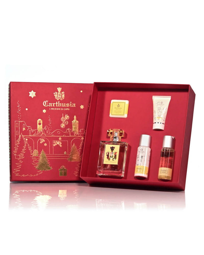 A luxurious red Carthusia Christmas La Certosa – Mediterraneo Gift Box open to reveal a Carthusia Eau de Parfum, two smaller bottles likely containing body care products, and a cream, all set against.
