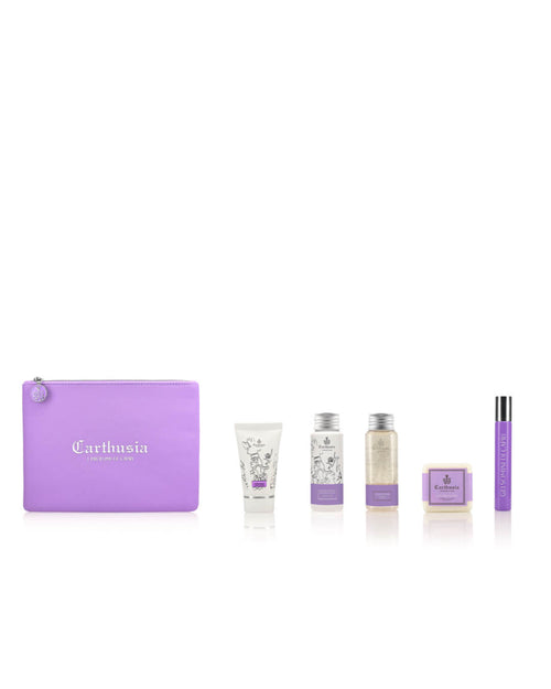 A set of Carthusia I Profumi de Capri-branded lavender-colored toiletries arranged in a row, including the Carthusia Gelsomini (Jasmine of Capri) Travel Clutch Bag, a cream tube, two small bottles, a bar of soap, and a spray container. The packaging features a consistent light purple and white color scheme with the Jasmine of Capri fragrance.