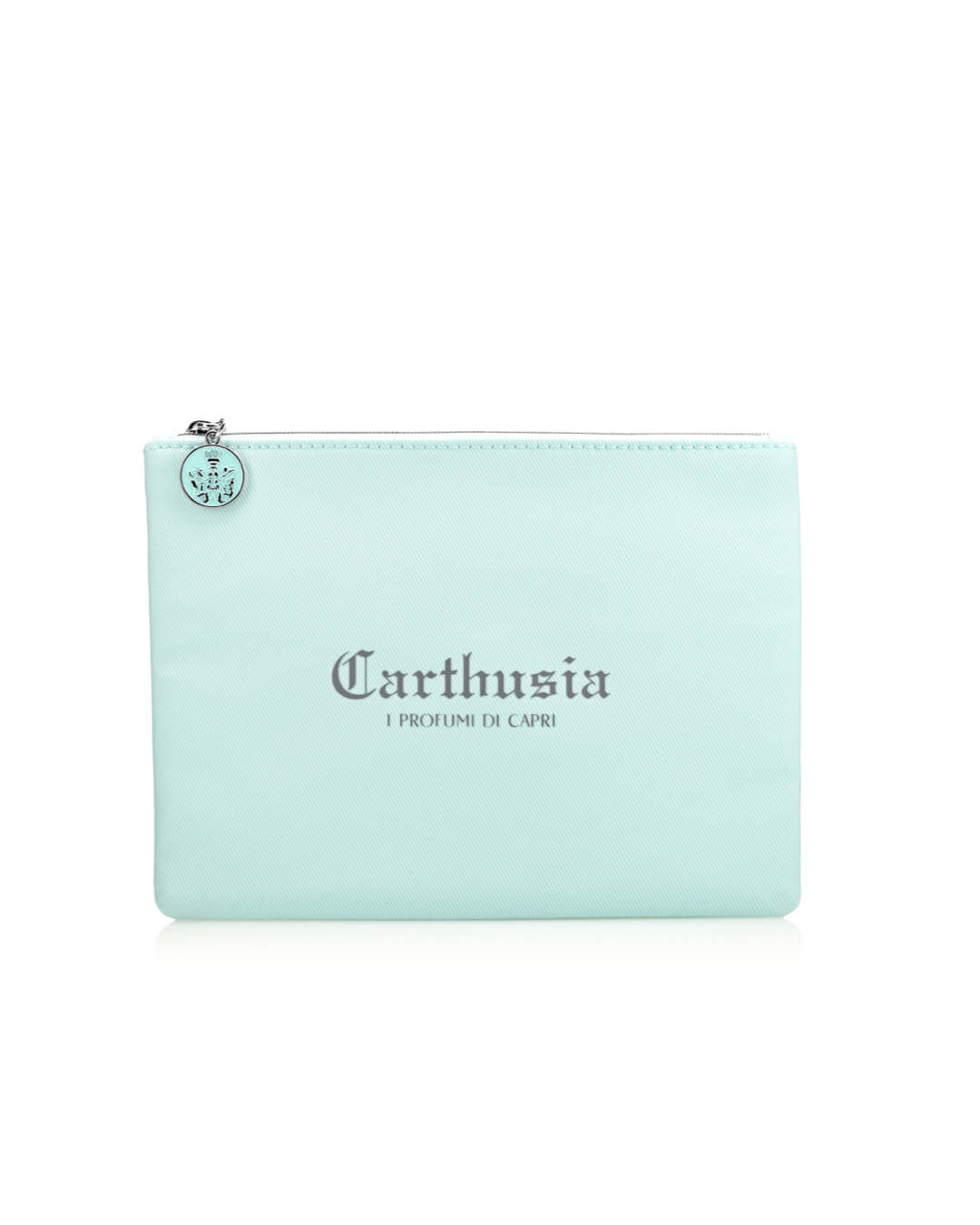 A light blue rectangular Carthusia Via Camerelle Travel Clutch Bag with a zipper at the top, featuring the brand name "Carthusia I Profumi di Capri" and the phrase "I Profumi di Capri" printed in dark gray letters. A small round charm with an emblem is attached to the zipper pull.