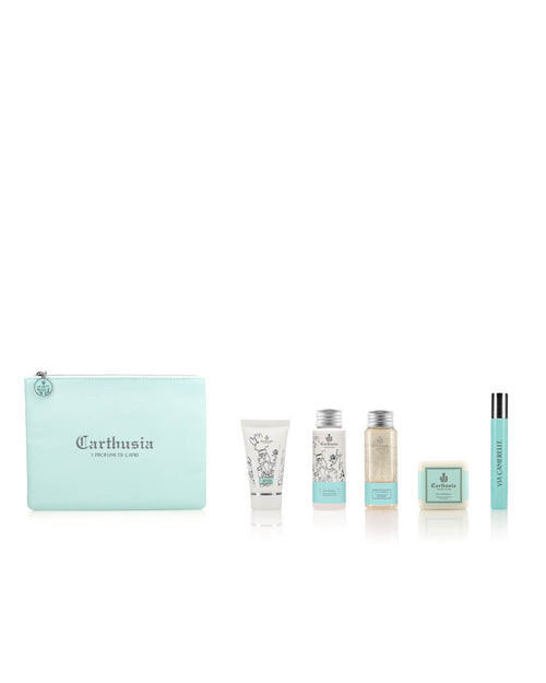 A light blue Carthusia I Profumi de Capri Carthusia Via Camerelle Travel Clutch Bag is displayed with five toiletry items arranged beside it: a white tube, two small bottles, a bar of soap, and a slim, upright tube. The items are neatly aligned against a plain white background, evoking the refreshing Capri fragrance.