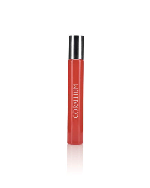 A tall, cylindrical red perfume bottle with a metallic silver cap. The bottle, named Carthusia Corallium Travel Clutch Bag by Carthusia I Profumi de Capri, has the word "CORALLIUM" printed vertically in white text down the front. Set against a plain white background, it evokes the essence of scented woods and fits perfectly into any travel clutch bag.