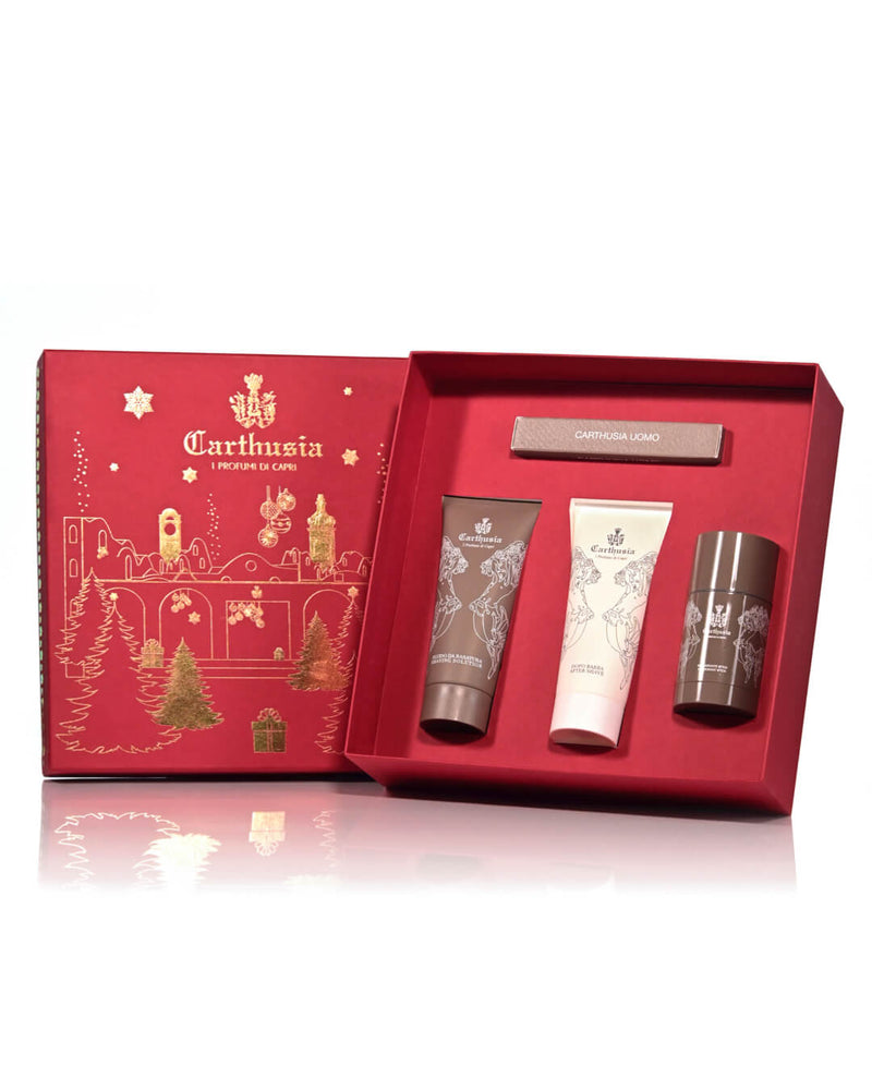 A luxurious Carthusia Christmas Via Krupp – Uomo gift set, featuring a red box with golden holiday-themed illustrations, containing three skincare products: a tube of cream, an Eau de Parfum, and another.