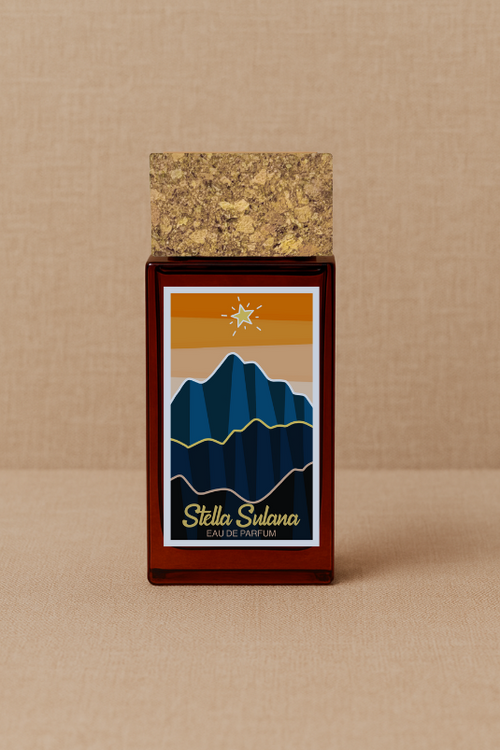 A perfume bottle with a cork cap is displayed against a beige background. Its label shows blue mountains beneath a setting sun, evoking Corsican scents, and reads "ISULA parfums Stella Sulana - Midday Star eaux de parfum.