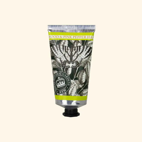 A silver tube of The English Soap Co. Kew Gardens Sandalwood and Pink Pepper Hand Cream features botanical black-and-white art, green and yellow borders, a black screw cap, and highlights sustainable luxury skincare.