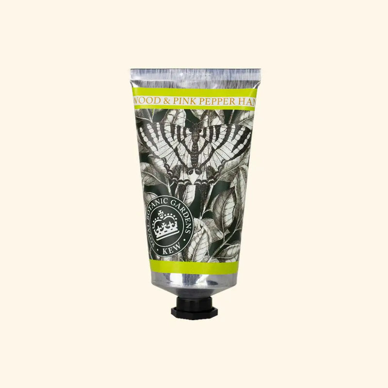 A silver tube of The English Soap Co. Kew Gardens Sandalwood and Pink Pepper Hand Cream features botanical black-and-white art, green and yellow borders, a black screw cap, and highlights sustainable luxury skincare.