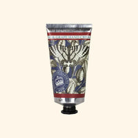 A metallic tube of The English Soap Co. Kew Gardens Fig and Grape Hand Cream features botanical illustrations, a dark screw cap, and a label with decorative leaf designs, highlighting British craftsmanship.