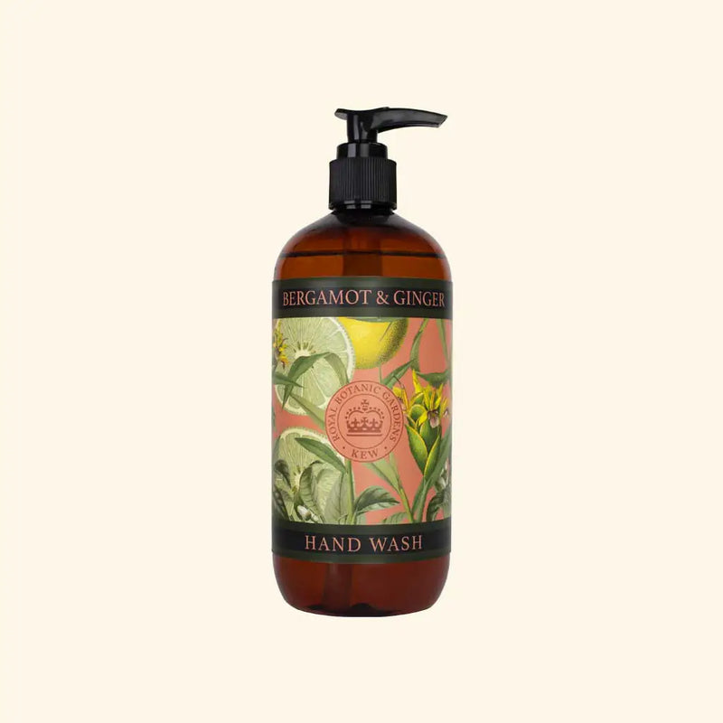 A brown pump bottle of The English Soap Co. Kew Gardens Bergamot and Ginger Hand Wash, featuring a decorative label with botanical illustrations of bergamot and ginger plants on a beige background. Infused with aloe vera, the label includes text reading "Bergamot & Ginger" and "Hand Wash.