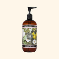 The English Soap Co. Kew Gardens Magnolia and Pear Hand Wash is a vegan hand wash in a brown pump bottle, featuring botanical illustrations of magnolia flowers and pears on a light cream label that captures the elegance of Kew Gardens.